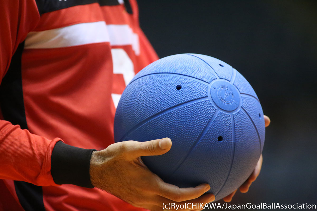 A player holds a goalball in his hands